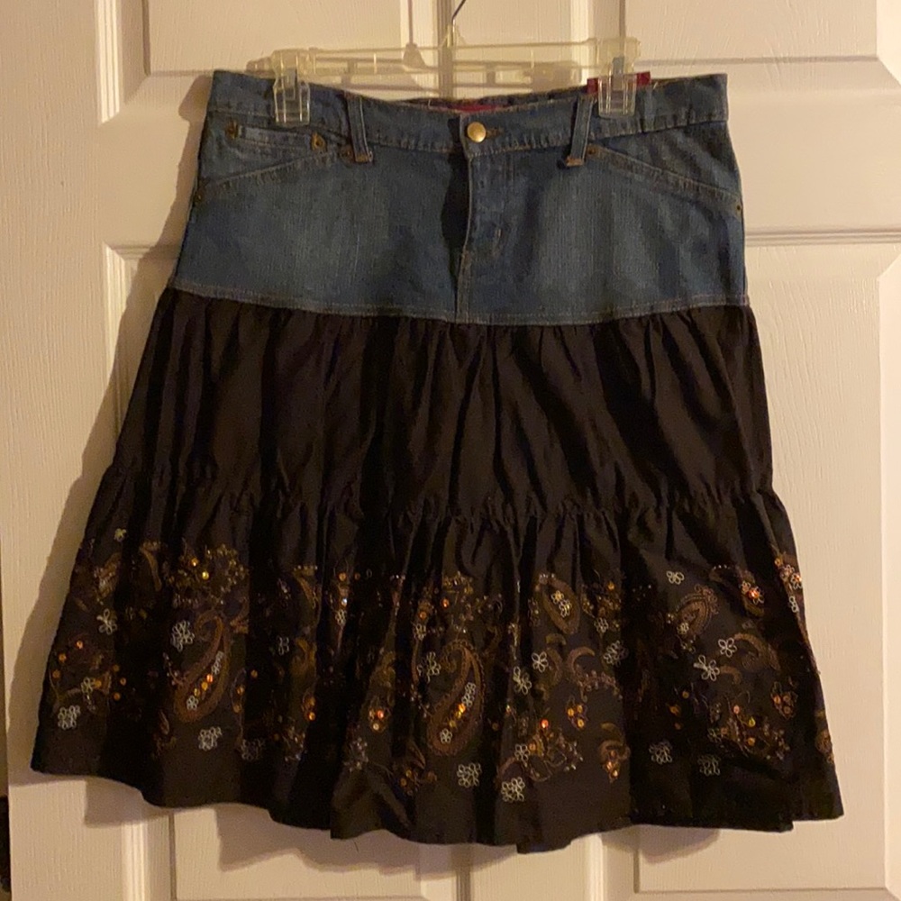 Denim skirt with brown material that has embroidery and sparkly embellishments.